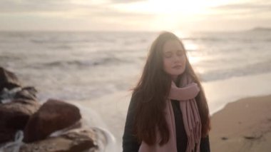 Gözleri kapalı, deniz kıyısında rüya gören güzel bir kız. Mucize dolu kadın fırtına sırasında okyanus kıyısında durup rahatlıyor. Dalgalar kayalık bir dalgada kırılıyor. Rüzgar saç savuruyor. Rüya gibi sinematik görüntüler..