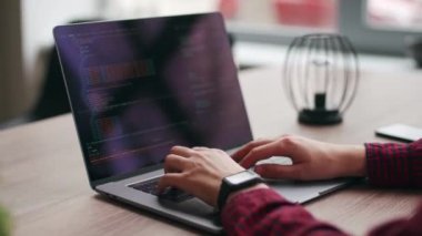 Serbest çalışanların ellerini dizüstü bilgisayarın klavyesinde daktilo koduyla kapat. Kamera geliştiricilerin etrafında slayt yapar parmaklar bilgisayar ekranına bir program kodu yazarlar. Çevrimiçi uygulama veritabanı üzerinde çalışan programcı.