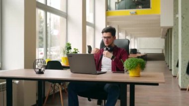 Laptop klavyesinde yazı yazan serbest yazar birlikte çalışma masasında oturuyor. Kamera geliştiricinin etrafında uçuyor ve ofiste bilgisayar ekranında program kodları yazıyor. Çevrimiçi uygulama üzerinde çalışan programcı
