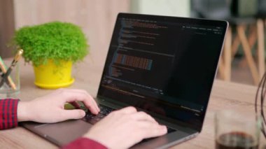 Serbest çalışanların ellerini dizüstü bilgisayarın klavyesinde daktilo koduyla kapat. Kamera geliştiricilerin etrafında slayt yapar parmaklar bilgisayar ekranında program kodunu yavaş çekimde yazar. Bir uygulama üzerinde çalışan programcı.