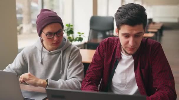 Zwei Hipster Mitarbeiter Tauschen Sich Geräumigen Großraumbüro Mit Laptops Über — Stockvideo