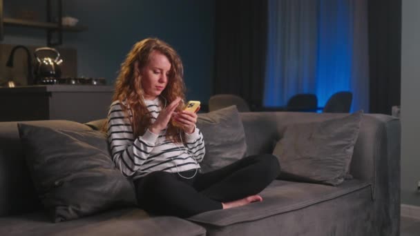 Mulher Rolando Smartphone Web Surf Sentado Sofá Elegante Sala Estar — Vídeo de Stock