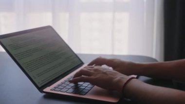 Kameralar kadın serbest çalışanların elleri etrafında kayıyor ve dizüstü bilgisayarda yavaş çekimde klavyeyle yazı yazıyorlar. Ofiste internetle çalışan iş kadını. Evden uzakta çalışan bir kız. Yavaş çekim takip çekimi..
