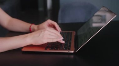 Kameralar kadın serbest çalışanların elleri etrafında kayıyor ve dizüstü bilgisayarda yavaş çekimde klavyeyle yazı yazıyorlar. Ofiste internetle çalışan iş kadını. Evden uzakta çalışan bir kız. Yavaş çekim takip çekimi..