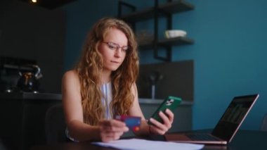 Mutlu kadın satın alıyor, Fintech uygulaması ile ödeme yapıyor. Alışverişci kız, kara cuma satışlarındaki malların parasını ödemek için mobil bankacılık uygulaması ve kredi kartı kullanıyor. Siparişin yerine getirilmesini bekleyen bir kadın..