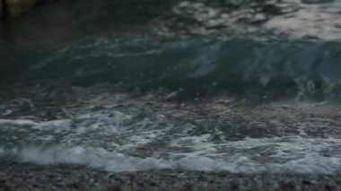 Deniz dalgalarının muhteşem manzarası dalgalanır ve kayalık kıyı şeridine kırılır. Okyanus dalgaları gelgit çekimlerinde kayalık okyanus kıyısına doğru akıyor. Skipper 'ın kızları. Beyaz atlar. Beyaz köpüklü dalgalar