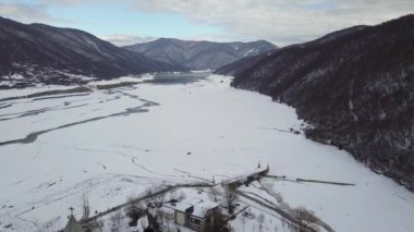 Gürcistan 'daki Aragvi Nehri' nde viyadük köprüsünün yanındaki ananürji kompleksinin havası. Kafkas dağlarında karlı kış manzarası.