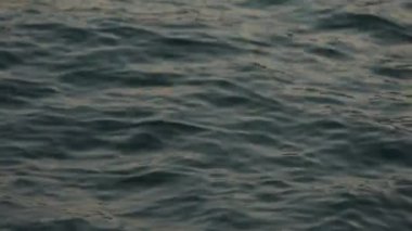 Sığ su yüzeyi dokusu döngüsü. Rahatsız deniz suyu yüzeyine yavaş çekimde yaklaşın. Deniz yüzeyi yavaş çekimde kapanır. Kuzey Denizi sakin dokuları. Günbatımı deniz manzarası, fırtınadan sonra deniz..
