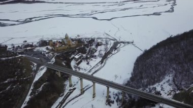 Gürcistan 'daki Aragvi Nehri' nde viyadük köprüsünün yanındaki ananürji kompleksinin havası. Kafkas dağlarında karlı kış manzarası.