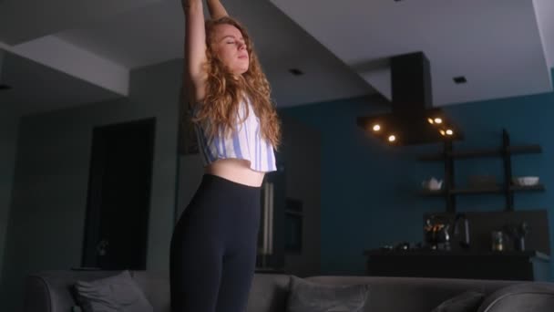 白人女人早上在家里做伸展运动 突然感到背痛 年轻的成年女性在做伸展运动时背痛 腰部抽筋的女孩揉背 — 图库视频影像