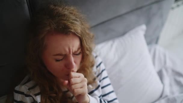 患流感的妇女咳嗽 在家里的床上打喷嚏 喉咙疼痛 发烧和头痛 年轻的高加索女性在与额头隔离的过程中 患上了眼镜蛇病 — 图库视频影像