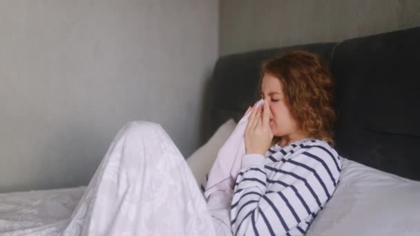患流感的妇女咳嗽 在家里的床上打喷嚏 喉咙疼痛 发烧和头痛 年轻的高加索女性在与额头隔离的过程中 患上了眼镜蛇病 — 图库视频影像