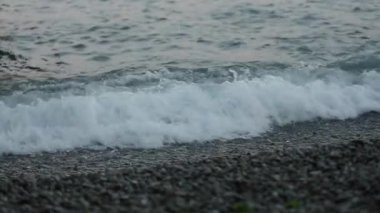 Deniz dalgalarının muhteşem manzarası dalgalanır ve kayalık kıyı şeridine kırılır. Okyanus dalgaları gelgit çekimlerinde kayalık okyanus kıyısına doğru akıyor. Skipper 'ın kızları. Beyaz atlar. Beyaz köpüklü dalgalar
