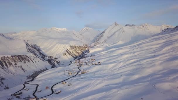 日出时分 滑雪场村雪山山脊的广阔空中全景 日落时 滑雪场上陡峭的山脉上覆盖着雪粉 高加索山脉的最高峰在日落上 — 图库视频影像