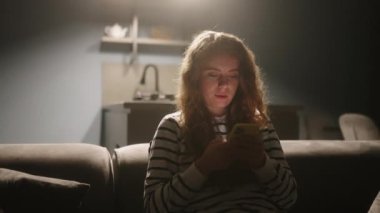 Akıllı telefonları kaydıran, internette sörf yapan gece şık oturma odasındaki kanepede oturan bir kadın. Mobil oyunlar oynayan ya da mağazadan alışveriş yapan bir kadın. Telefonu olan kız sosyal ağlarda sohbet etmekten hoşlanıyor.