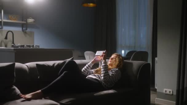 Frau Scrollt Smartphone Surft Internet Liegt Nachts Auf Dem Sofa — Stockvideo