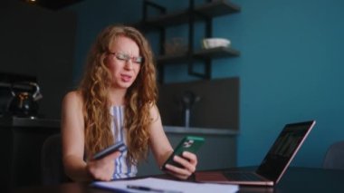 Akıllı telefonu olan gergin bir kadın, banka kartı faturasını ödemede sorun yaşıyor, banka uygulamasının şifresini unutmuş. Kadın yetersiz fonlar, yaptırımlar ve güvensiz transfer nedeniyle ödeme yapamıyor. Başarısız bir aktarım.