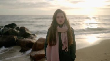 Deniz kıyısında rüya gören üzgün düşünceli kızın portresi. Fırtına sırasında okyanus kıyısında kameraya bakan düşünceli bir kadın. Rüzgârlı dalgalı saçlar. Yavaş çekim rüya gibi sinematik görüntüler.