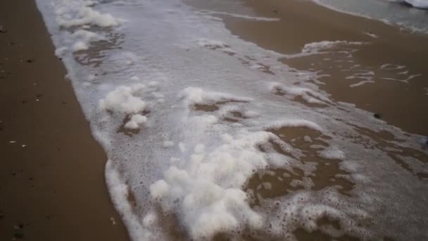 모래사장 에서바람에 날리는 거품은 서서히 폭풍이 몰아치는 날에는 바닷물 바다를 — 비디오