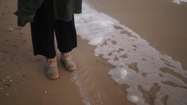 Mujer Pie Botas Junto Espuma Del Mar Soplado Por Viento — Vídeo de stock