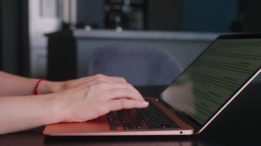 Kameralar kadın serbest çalışanların elleri etrafında kayıyor ve dizüstü bilgisayarda yavaş çekimde klavyeyle yazı yazıyorlar. Ofiste internetle çalışan iş kadını. Evden uzakta çalışan bir kız. Yavaş çekim takip çekimi..