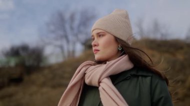 Üzgün düşünceli kadın sahilde duruyor ve karamsar bulutlu bir günde deniz manzarasına bakıyor. Depresyondaki düşünceli yalnız kadın okyanus kenarında fazla düşünüyor. Rüzgar karışık etnik kız havadar saçlarını savuruyor. Yavaş çekim.