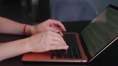 Kameralar kadın serbest çalışanların elleri etrafında kayıyor ve dizüstü bilgisayarda yavaş çekimde klavyeyle yazı yazıyorlar. Ofiste internetle çalışan iş kadını. Evden uzakta çalışan bir kız. Yavaş çekim takip çekimi..