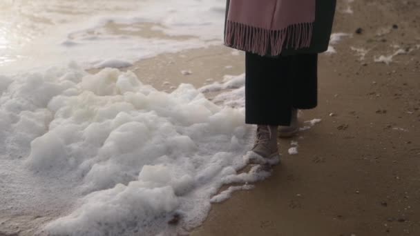 Kadın Deniz Köpüğü Boyunca Botlarıyla Yürüyor Kumlu Sahilde Rüzgar Tarafından — Stok video