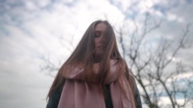 Üzücü karışık etnik kadın kameraya bakıyor, dönüyor, deniz sahiline iniyor. Rüya gibi vinç resmi. Düşünceli dişi yapraklar, okyanusa giden merdivenlerden aşağı yürür. Korkunç kuru ağaç dalları..