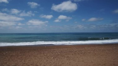 Gorgeous view of ocean waves surge and break into the sandy shoreline. Sea waves running towards sandy ocean shore during tide closeup shot. Skippers daughters. White horses. Waves with white foam