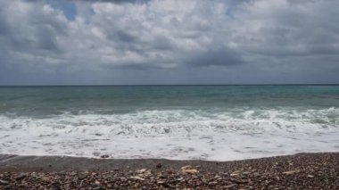 Gorgeous view of sea waves surge and break into the rocky shoreline. Ocean waves running towards rocky ocean shore during tide closeup shot. Skippers daughters. White horses. Waves with white foam