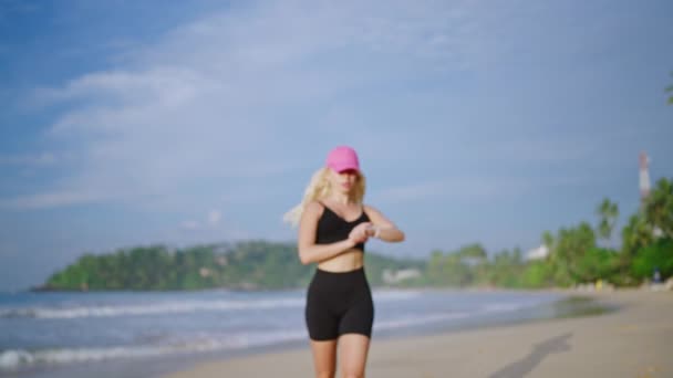 Młoda Blondynka Biegająca Nad Morzem Wschodzie Słońca Patrzy Zegarek Fitness — Wideo stockowe