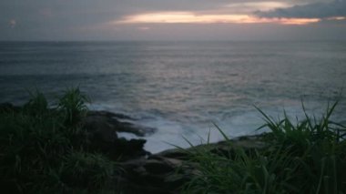 Breathtaking scenic view of ocean from picturesque green hill covered with plants. Calm remote healing place for self reflexion and meditation by ocean. Serene soothing spot with wonderful sea view