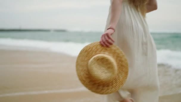 Female Legs Feet Long White Dress Carries Straw Hat Walking — Stockvideo