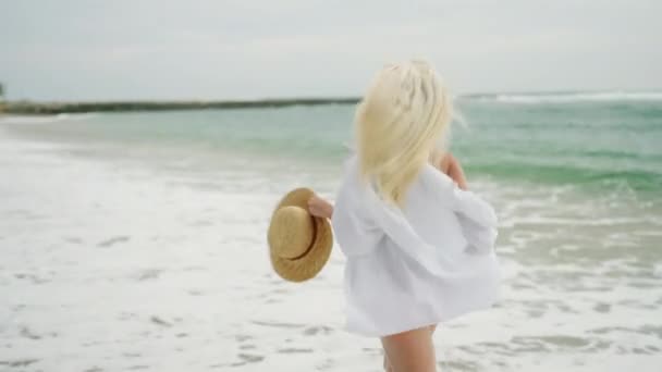 Young Blonde Woman Running Away Camera Beach Wearing White Shirt — Stockvideo