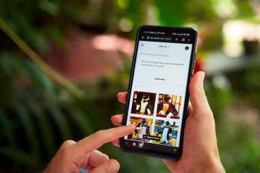 February 5, 2023, Mirissa, Sri Lanka. Using OpenAI DALL-E on phone. Woman testing artificial intelligence image generator. Person creating pictures via neural network online close-up. Human vs AI