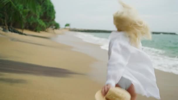 Young Blonde Woman Runs Away Camera Beach Wearing White Shirt — Vídeo de Stock