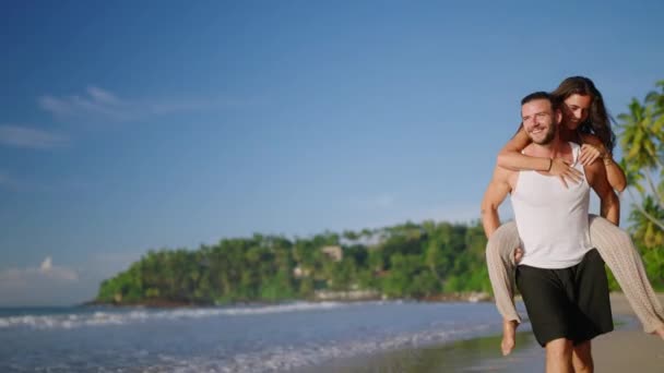 แฟนแบกแฟนไว ความสน กสนานท ชายหาดในว นฤด ความส วเราะร าเร งบนชายหาดล อเล — วีดีโอสต็อก