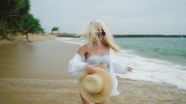 Young Blonde Woman Runs Away Camera Beach Wearing White Shirt — Stockvideo