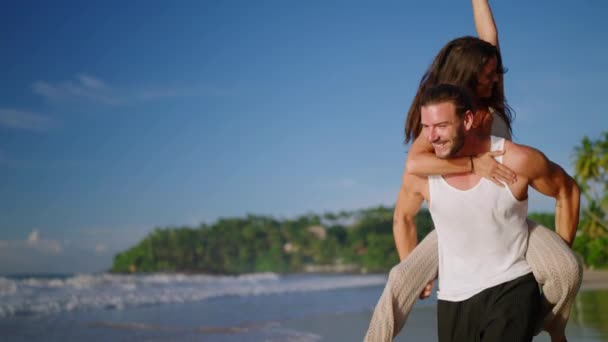 Sevgilisini Sırtında Taşıyan Erkek Arkadaşı Yaz Günü Deniz Kenarında Eğleniyor — Stok video