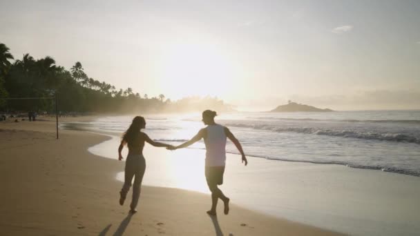 Молодая Счастливая Пара Держащаяся Руки Бегающая Валяющаяся Пляже Вместе Наслаждаясь — стоковое видео