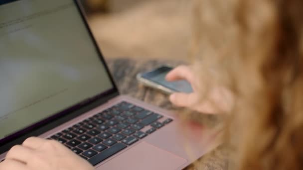 Vrouwelijke Ontwikkelaar Typen Laptop Neemt Telefoon Met Diagrammen Controleert Statistieken — Stockvideo