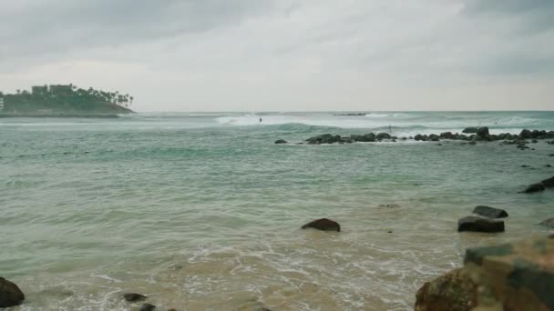波涛汹涌的大海 背景是岩石和一个绿色的岛屿 海洋广阔的风景 美丽的蓝色大海和平静的巨浪漂浮在印度洋上 海洋和天空背景景观 — 图库视频影像