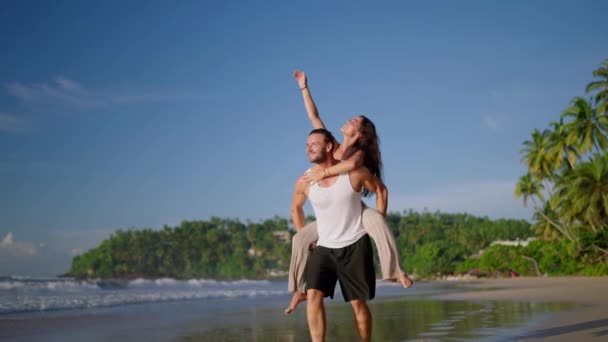 Sevgilisini Sırtında Taşıyan Erkek Arkadaşı Yaz Günü Deniz Kenarında Eğleniyor — Stok video