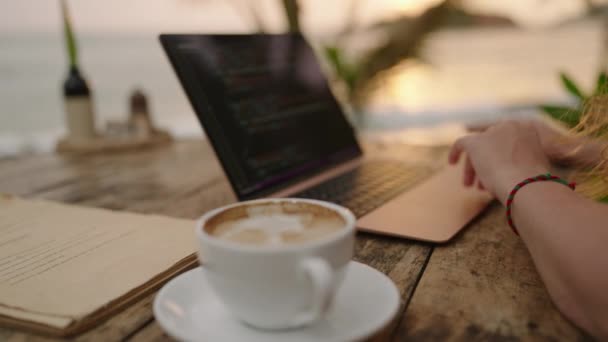 日落时 年轻的女开发人员在海边的笔记本电脑上工作 室外热带咖啡店的女自由撰稿人 白人女孩在异国他乡的电脑上远程打字 — 图库视频影像