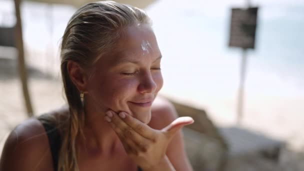 Blonde Blanke Vrouwelijke Surfer Die Zonnebrandcrème Haar Gezicht Aanbrengt Gelooide — Stockvideo