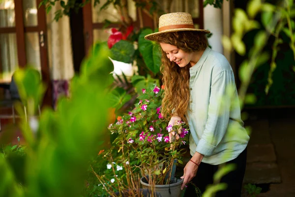 站在花园里种花浇花的年轻女子笑着 带园艺工具的幼女园艺师在果园照料盆栽 耕作和园艺概念 — 图库照片