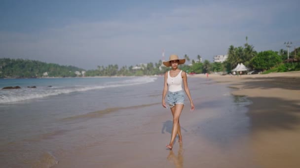 エキゾチックな島での熱帯の休暇に海のビーチを歩く多民族の黒人女性 アフリカ系アメリカ人の女性は海の海岸で藁帽子で太陽を楽しんでいます Bipoc女の子は旅行ツアーでリラックス — ストック動画