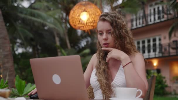 专注于严肃的女性思考问题的解决方案 在计算机上远程工作 专注于热带户外地点的女性关注笔记本电脑学习 在网上做项目 — 图库视频影像