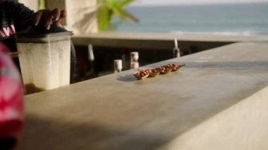 Deniz manzaralı açık bar tezgahında küçük şirin tabaklar içinde atıştırmalıklar. Barmen milkshake, kokteyl barın arkasında deniz manzaralı blender yapar. Açık hava büfesi. Açık hava yemeği ve kokteyl partisi.